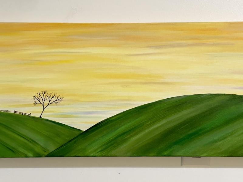 golden sky with moon. Rolling green hills with one tree