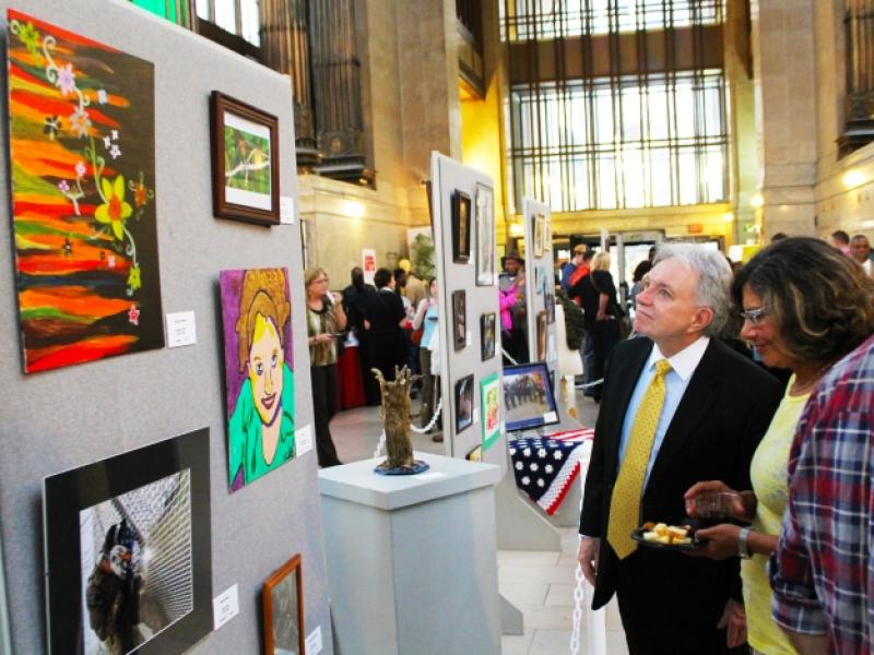 14th Annual Exhibit Director of Human Relations Commission, Charles Morrison taking in the artwork on display with fellow attendees.