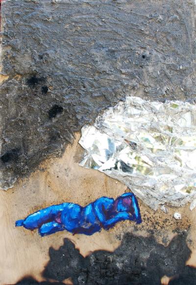 blue figure on burnt wood with broken glass and ashes