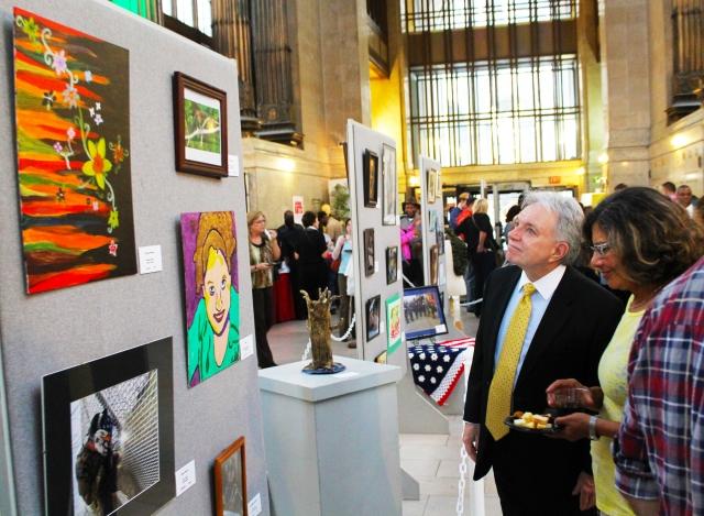14th Annual Exhibit Director of Human Relations Commission, Charles Morrison taking in the artwork on display with fellow attendees.