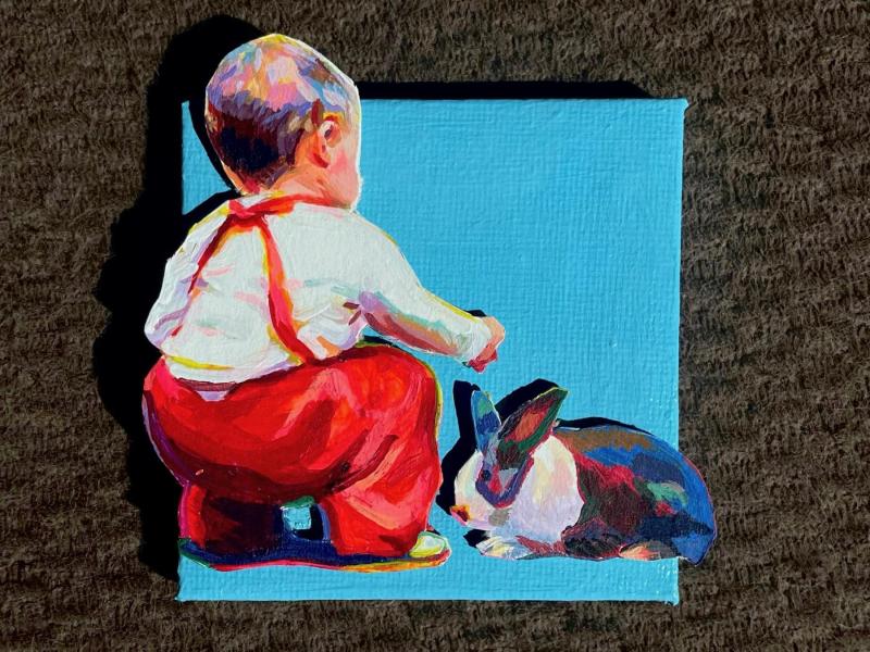 A little boy in red overalls going to pet a bunny. His back is towards us. The figure and bunny are on a separate surface than the canvas and are hanging over the edges. 