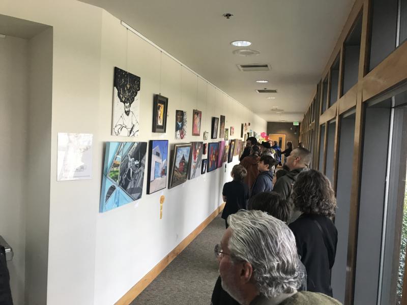 16th Annual Exhibit Attendees taking in the art lined walls of the Finely Community Center